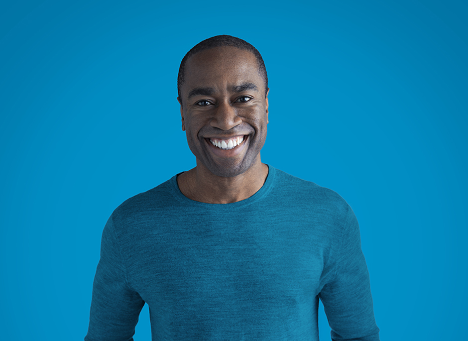 Portrait of smiling man against a blue background.